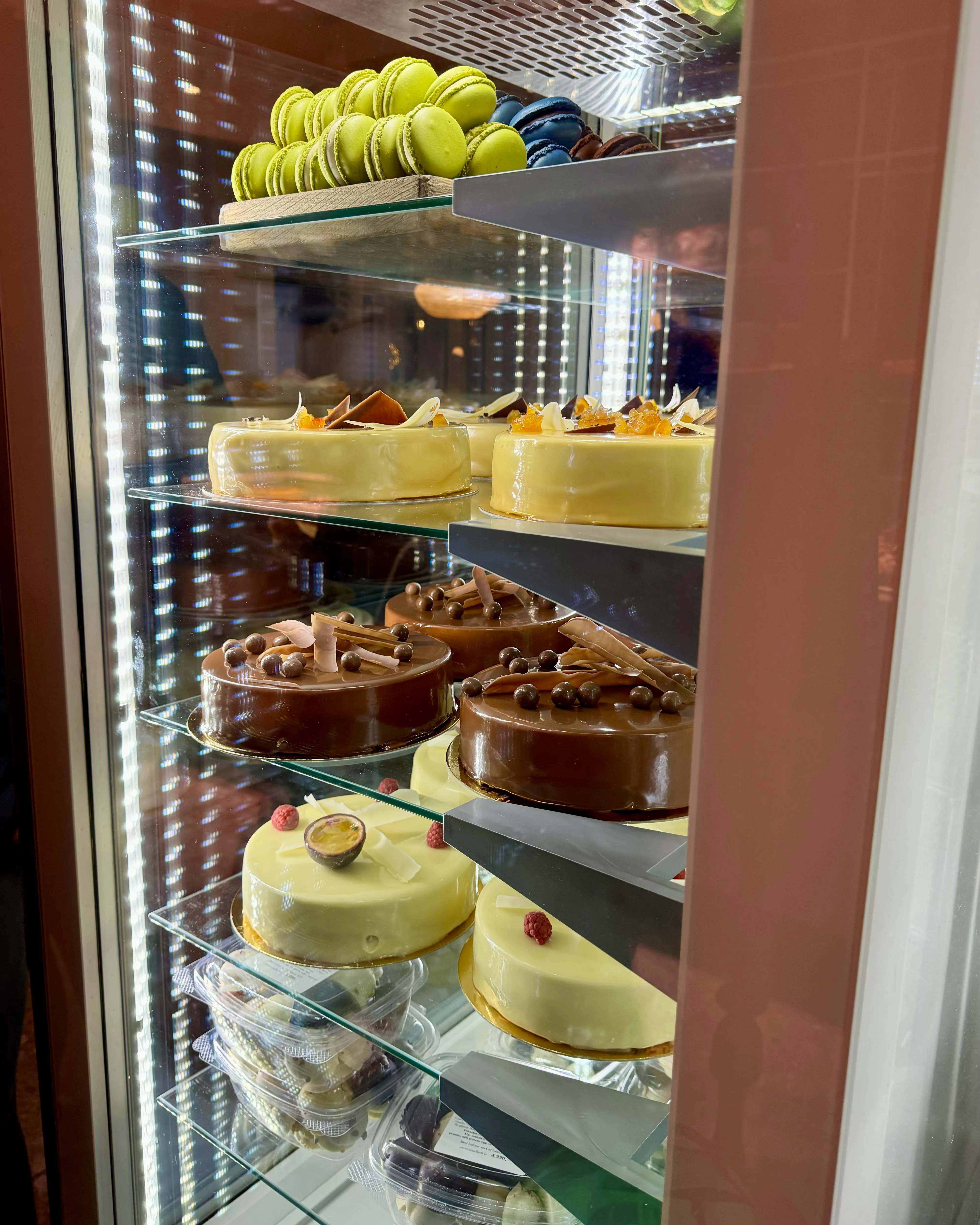 Mirror-like cakes topped with passion fruit in a display case