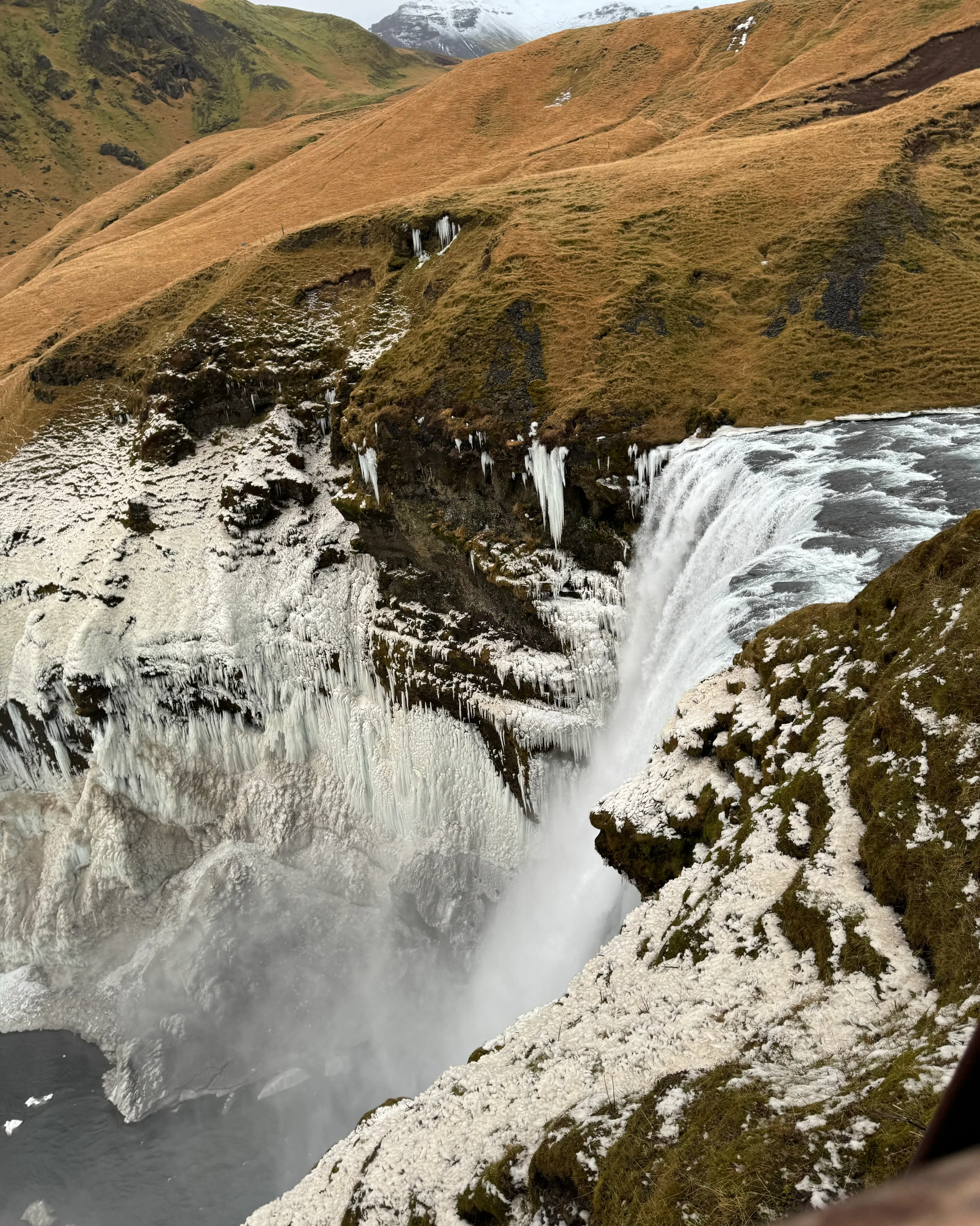 A waterfall surrounded by ice and snow