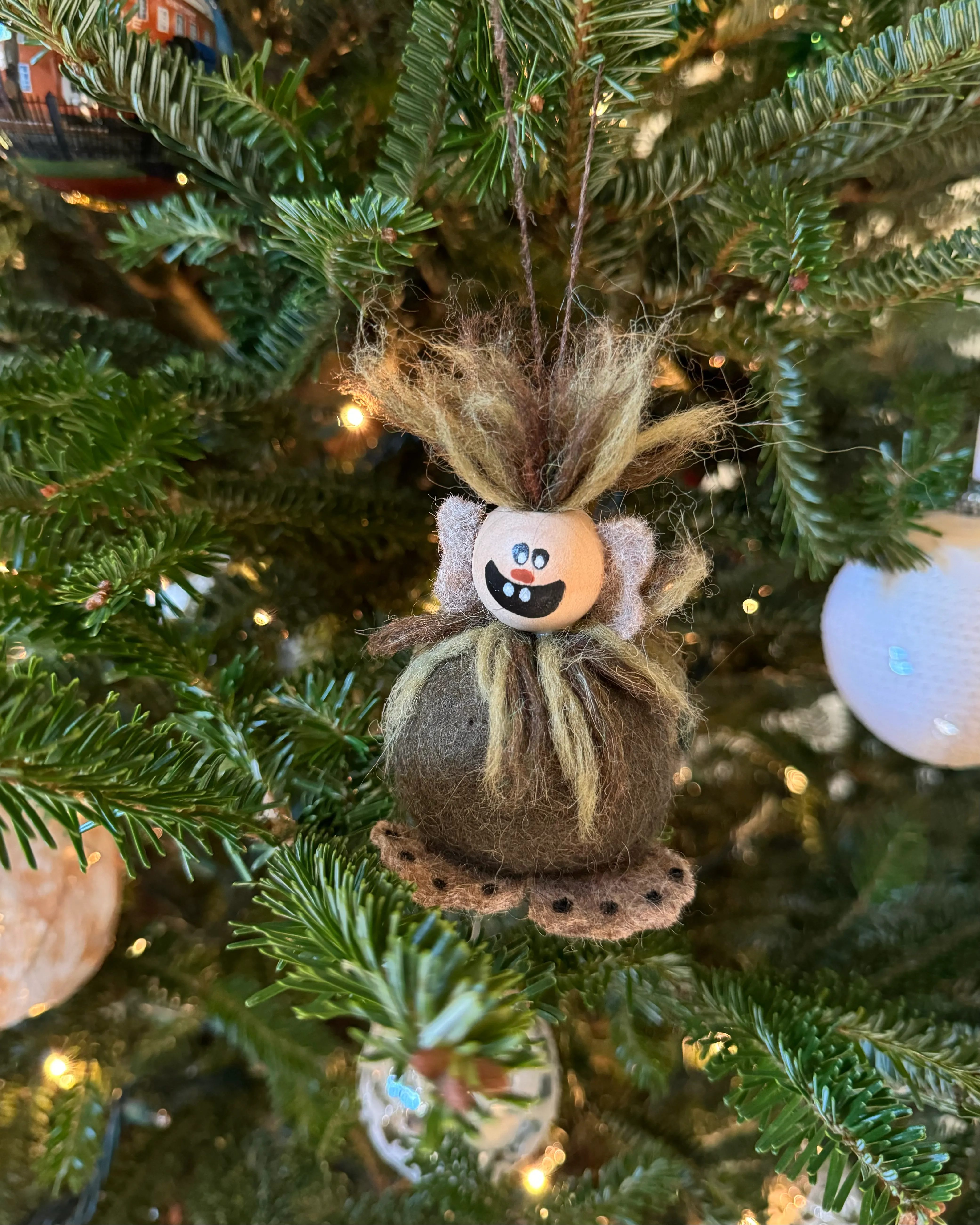 A troll Christmas ornament on a tree